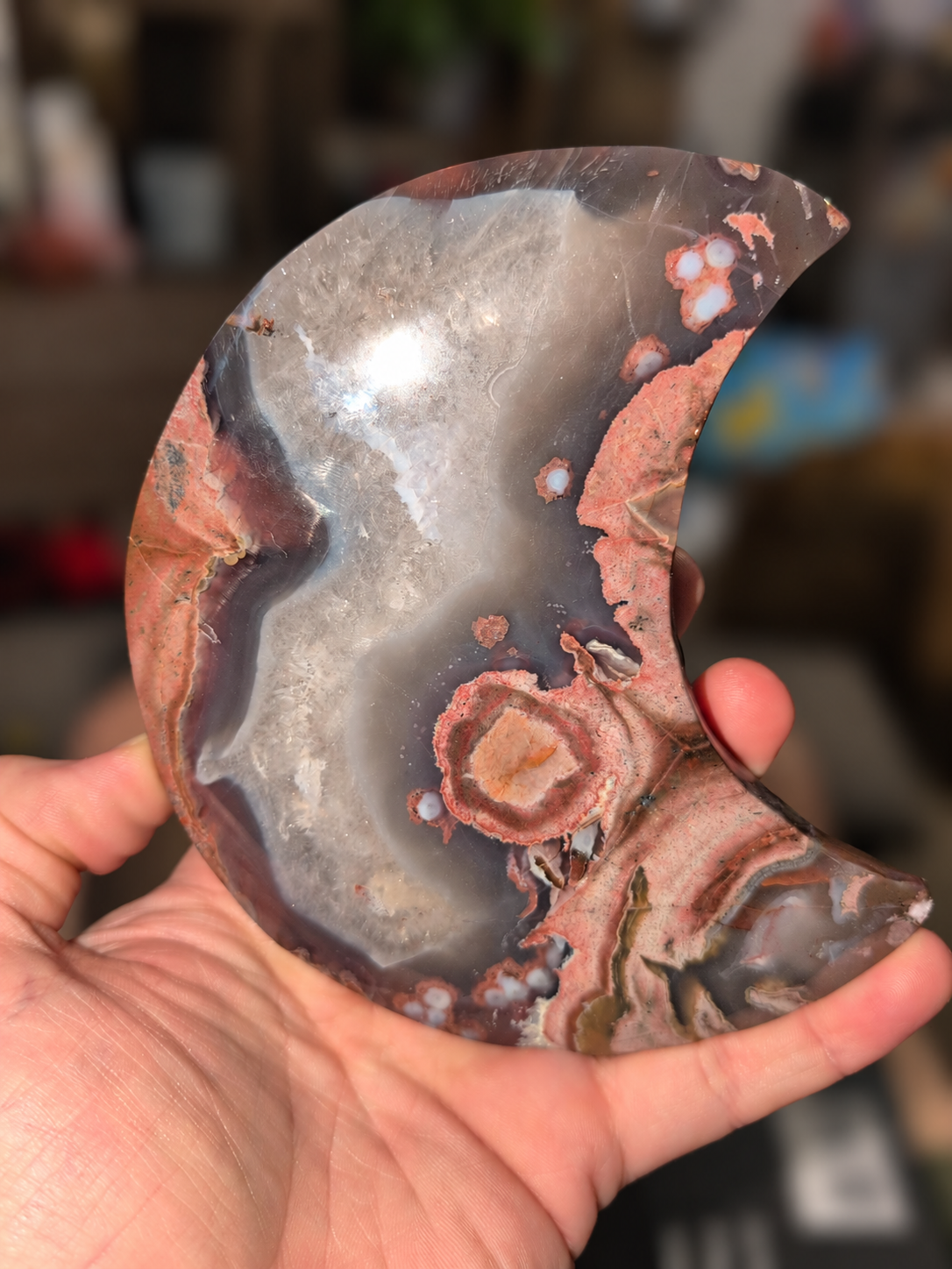 Polished crescent moon stone held in a hand