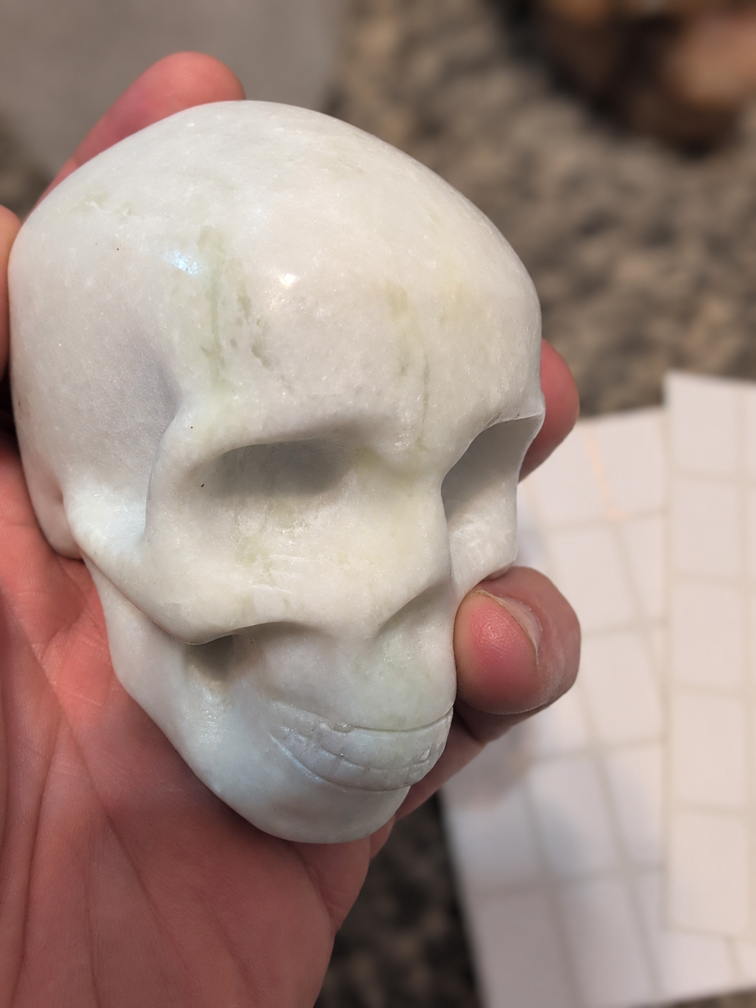 Carved white stone skull held in a hand